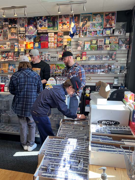 In side our store image with a focus on two customers looking through hockey cards