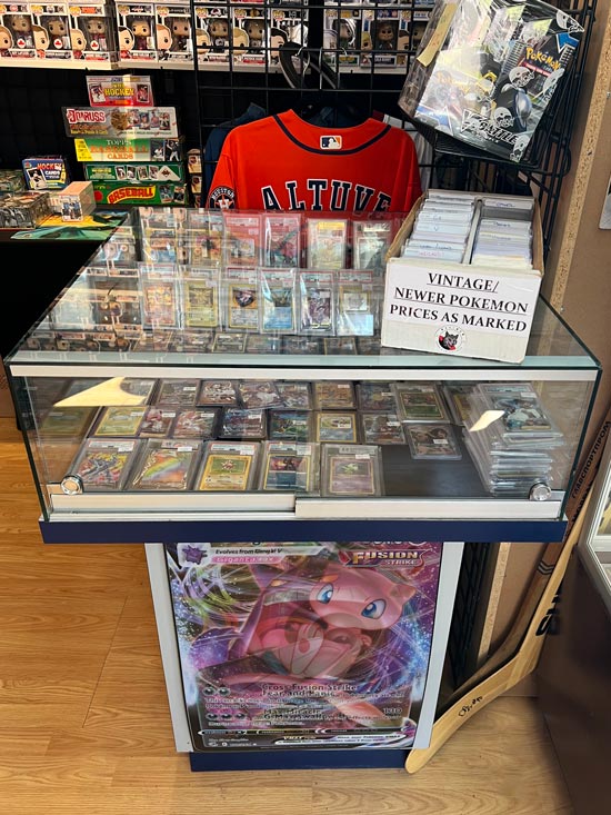 In side our store image with a focus on a glass case with Pokémon cards