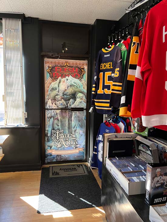 In side our store image with a focus on jerseys for sale, and hangers on the wall.