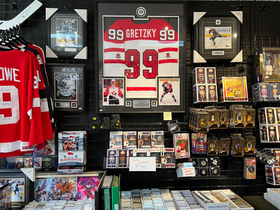 In side our store image with a focus on a Gretzky 99 Jersey, framed and holding a puck, 2 images and a plaque.